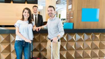 Pareja con maletas realizando el check-in