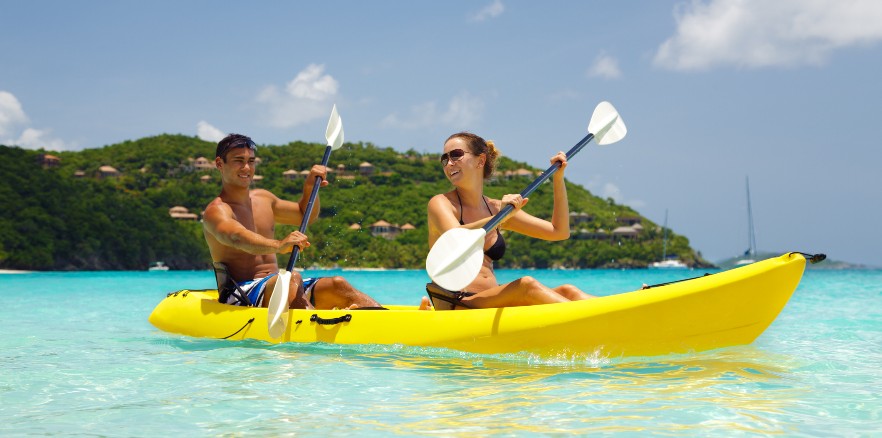 playas del caribe: hombre y mujer en kayak cerca de una montaña