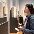 Mujer con auriculares observa una exposición en un museo.