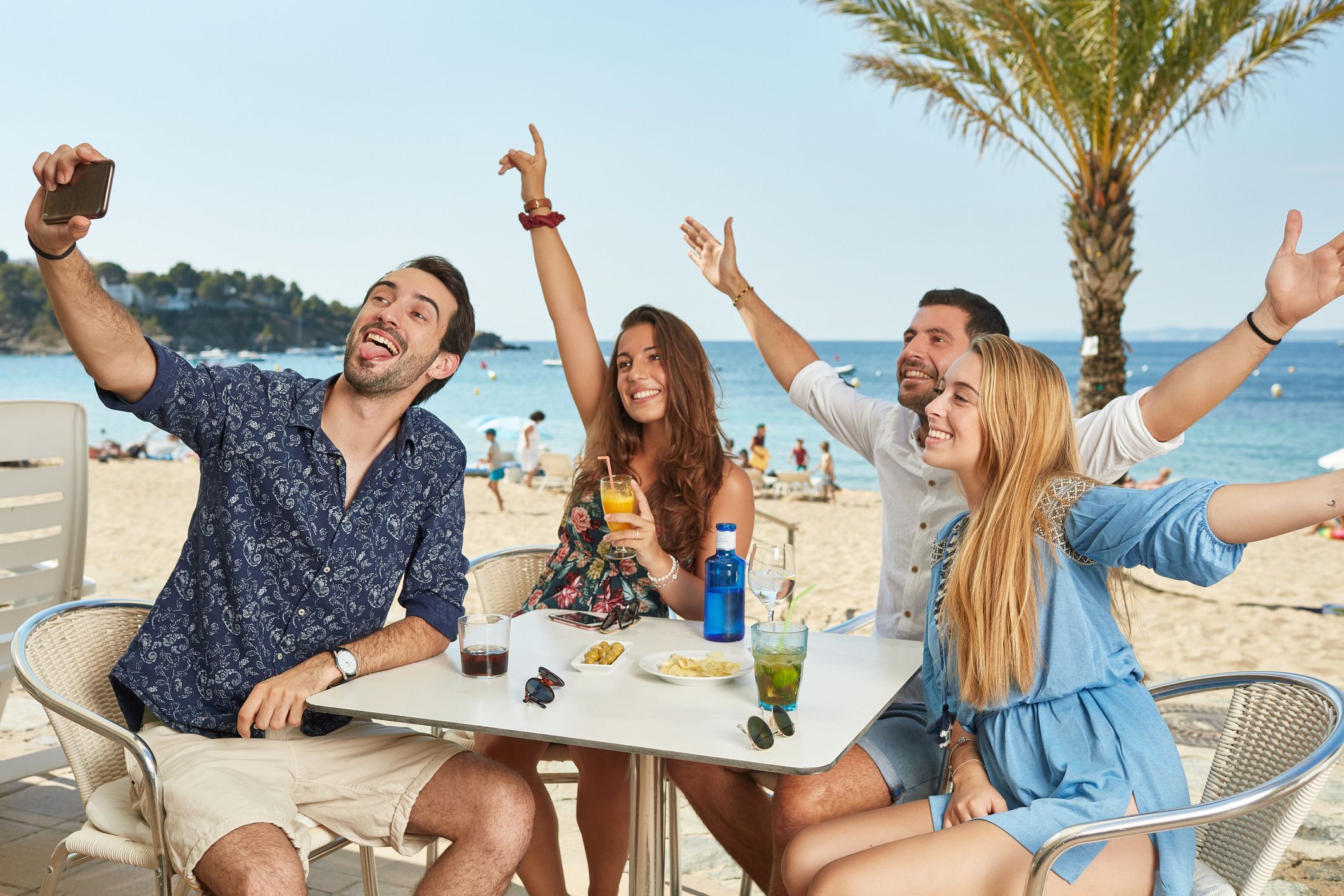 qué comer en punta cana: amigos comiendo y bebiendo en la playa