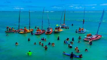Playa en Maceió con varios barcos y personas en el agua