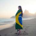Mujer envuelta en la bandera de Brasil en la playa
