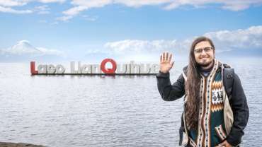 Hombre saludando para una foto frente al Lago Llanquihue