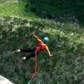 Mujer saltando en bungee jumping en medio de la naturaleza.