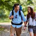 Pareja haciendo senderismo con mochila y cámara fotográfica