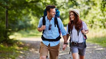 Pareja haciendo senderismo con mochila y cámara fotográfica