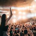 Mujer disfrutando de un concierto sobre el hombro de su amigo
