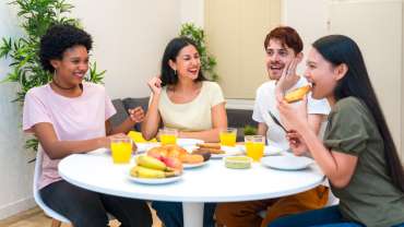 Grupo de amigos desayunando juntos en una casa alquilada a través de Couchsurfing