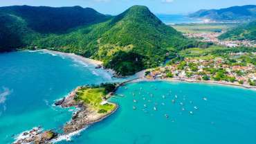 Paisaje de playa con aguas cristalinas y montañas verdes
