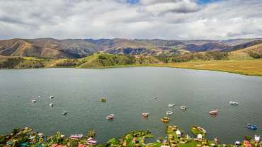 Pequeña ciudad a orillas del mar con algunas montañas y árboles