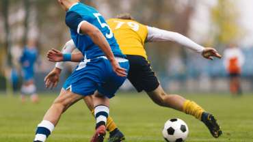 Jugadores en un partido de fútbol disputando el balón