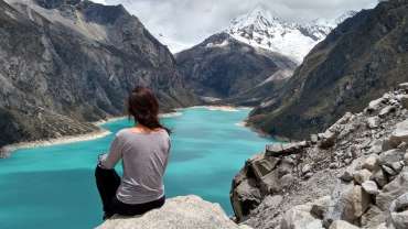 Mujer tomando una foto de espaldas observando el paisaje de la ciudad de Huaraz