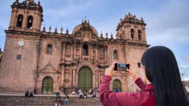 Mujer tomando una foto de un lugar turístico