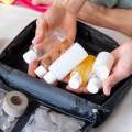 Manos organizando algunos productos en pequeños frascos dentro de un neceser