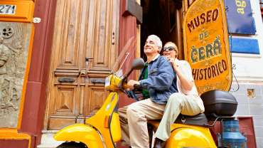Pareja de ancianos en una motoneta en el museo de cera histórico
