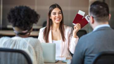 Mujer sosteniendo dos pasaportes con una sonrisa