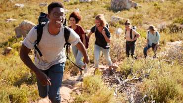 Grupo de amigos con mochilas haciendo senderismo