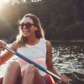 Mujer sonriente remando en canoa en el río Itata.