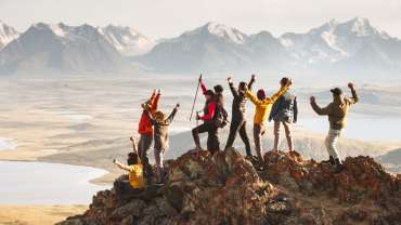 Grupo de personas celebrando haber llegado a la cima de una montaña