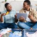 Pareja negra separando maletas y tarjeta para el viaje