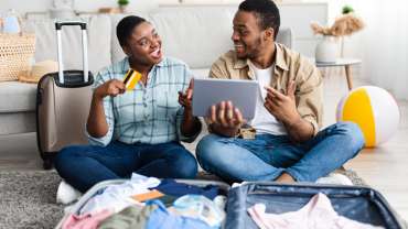 Pareja negra separando maletas y tarjeta para el viaje