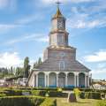 Imagen de iglesia rodeada por casas y céspedes
