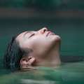 Rostro femenino sumergiéndose en las termas de Cajón del Maipo