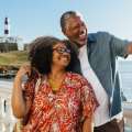 Pareja mayor negra tomándose una foto sonriendo en un sitio turístico