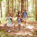 Pareja con sus hijos paseando por el bosque.