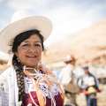 Mujer sonriente en atuendo tradicional con sombrero blanco