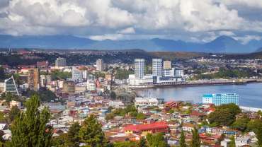 Vista urbana de Puerto Montt junto al mar y montañas.