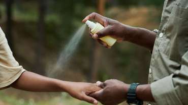 Padre aplicando repelente a su hija