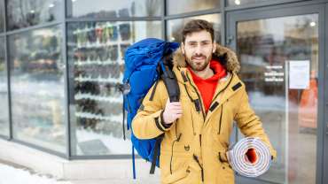 Hombre con mochila frente a tienda