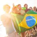 Grupo de amigos con bandera brasileña en la playa