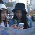 Turistas usando mapa y celular para orientación urbana